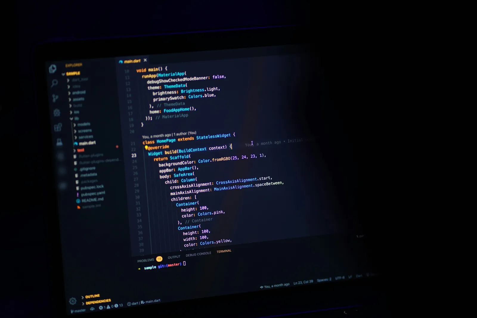 Code open in an editor on a monitor in a dark room.